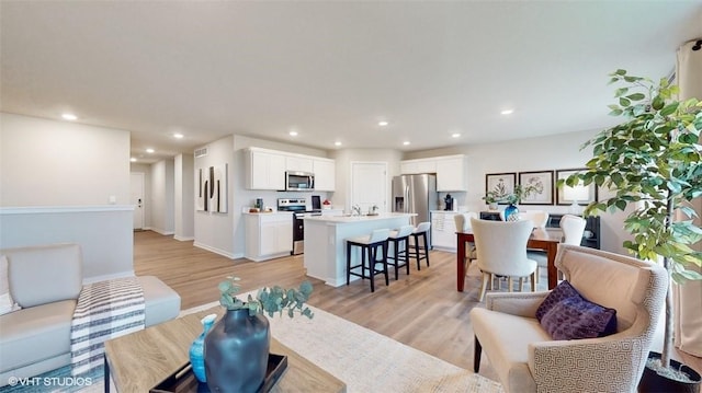 living room with light hardwood / wood-style floors and sink