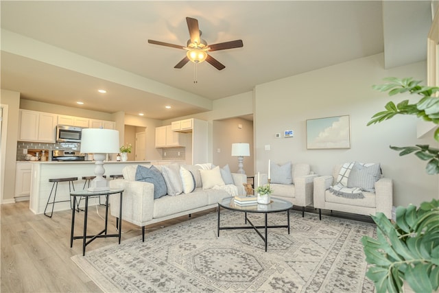 living room featuring ceiling fan and light wood-type flooring