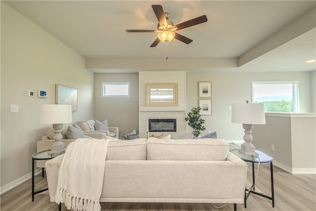 living room with a large fireplace, ceiling fan, and hardwood / wood-style floors