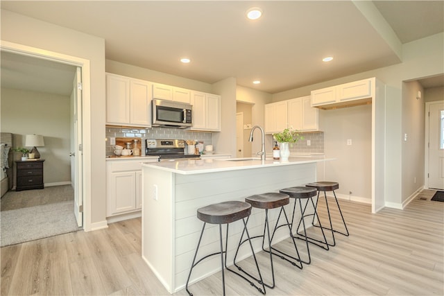 kitchen with appliances with stainless steel finishes, white cabinetry, and sink