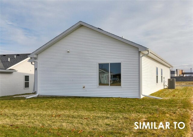 back of property featuring central AC unit and a yard