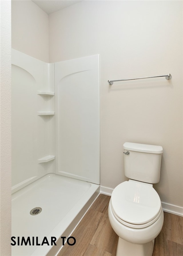 bathroom featuring a shower, toilet, and hardwood / wood-style flooring