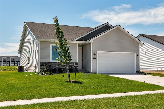 view of front of property with a front yard, a garage, and central AC unit