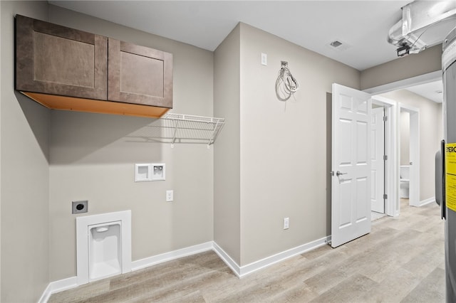 washroom with light hardwood / wood-style floors, hookup for an electric dryer, cabinets, and washer hookup