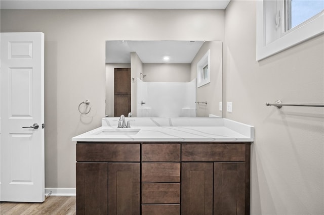 bathroom with vanity, hardwood / wood-style flooring, and walk in shower