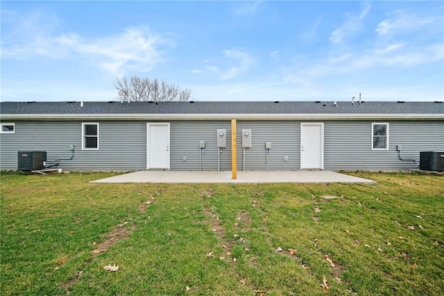 rear view of property with a lawn, cooling unit, and a patio