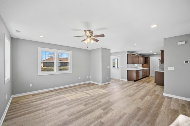 unfurnished living room featuring light wood-type flooring and ceiling fan