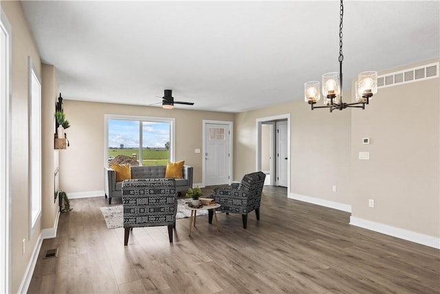 living room featuring ceiling fan with notable chandelier and wood-type flooring