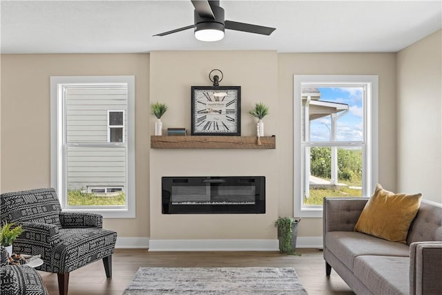 living area featuring light hardwood / wood-style floors and ceiling fan