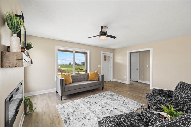 living room with ceiling fan and light wood-type flooring