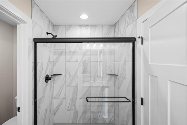 bathroom featuring a stall shower and toilet