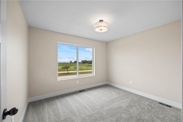 unfurnished room with carpet, visible vents, and baseboards