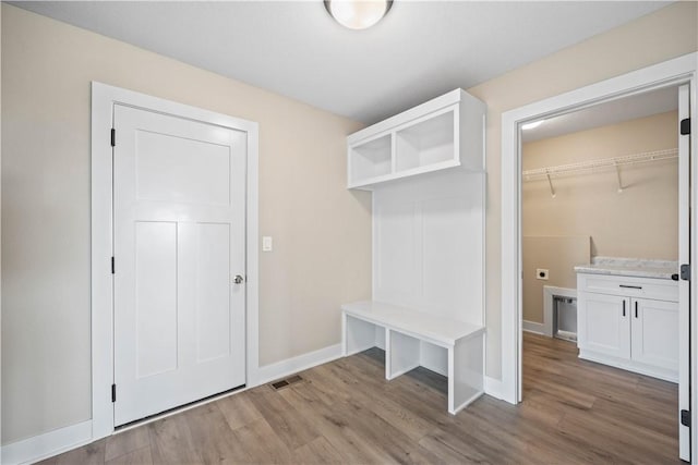 mudroom featuring wood finished floors, visible vents, and baseboards