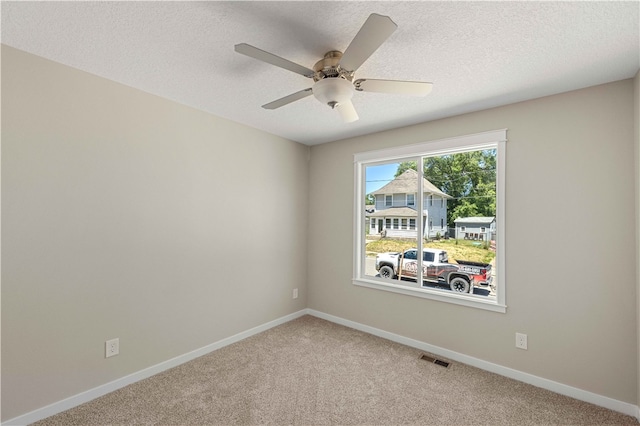 unfurnished room featuring a textured ceiling, carpet, and ceiling fan