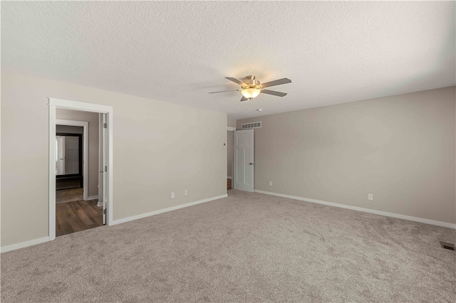 carpeted spare room with ceiling fan and a textured ceiling