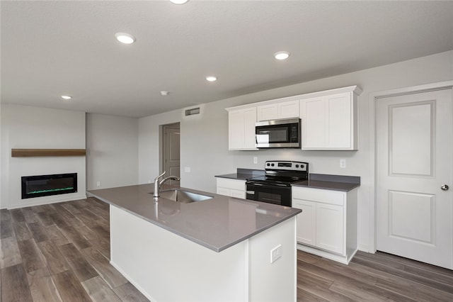 kitchen with sink, white cabinetry, stainless steel appliances, and a kitchen island with sink