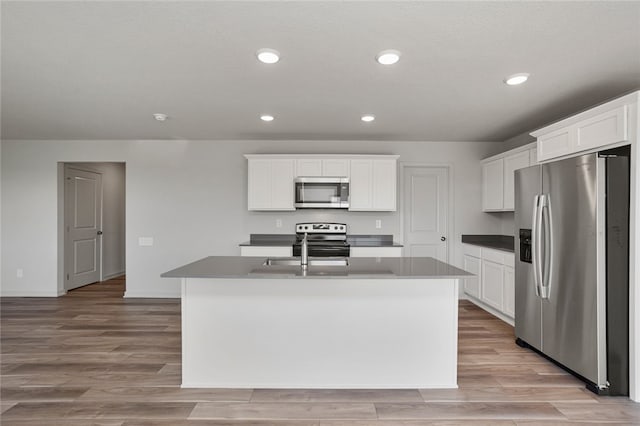 kitchen featuring white cabinets, a kitchen island with sink, and appliances with stainless steel finishes