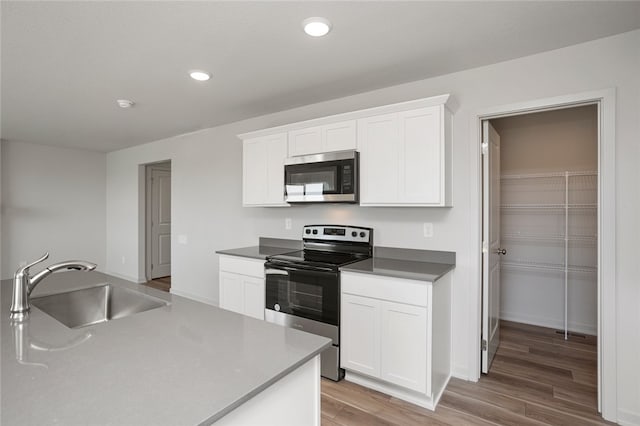 kitchen featuring white cabinetry, sink, and appliances with stainless steel finishes