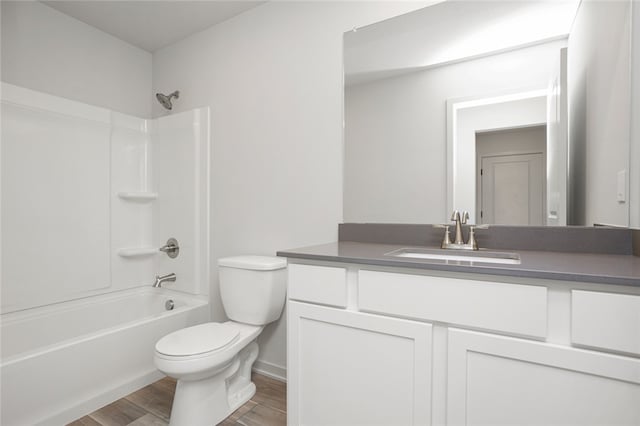 full bathroom with washtub / shower combination, vanity, hardwood / wood-style flooring, and toilet