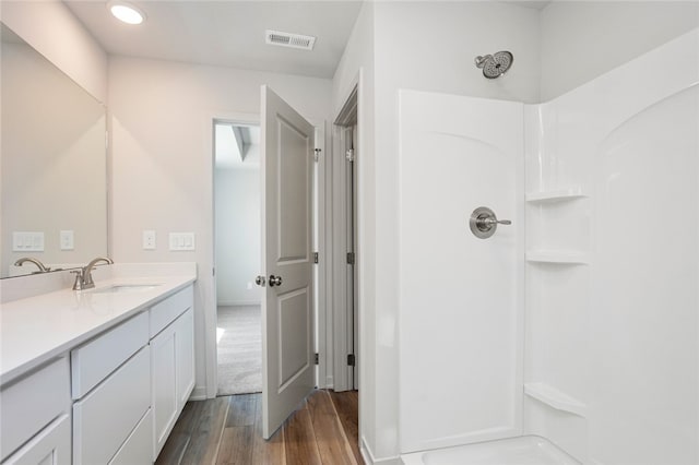 bathroom with a shower, vanity, and hardwood / wood-style flooring