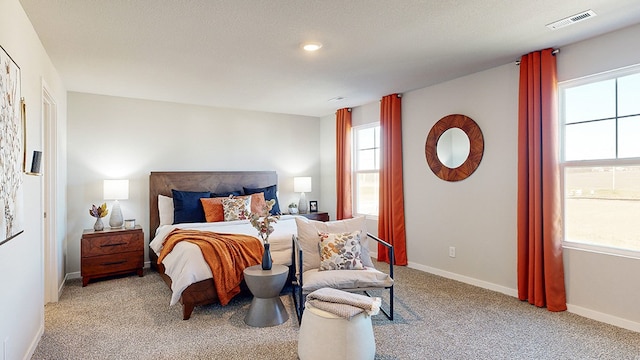 bedroom with light carpet and a textured ceiling