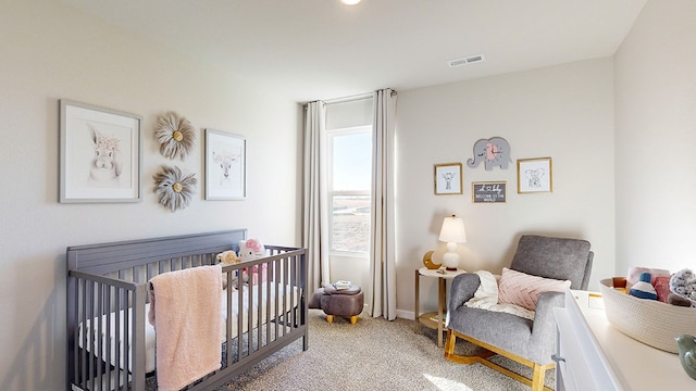 bedroom with light colored carpet and a nursery area