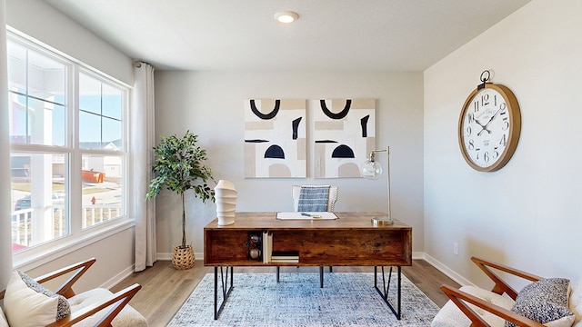 office area with a wealth of natural light and light hardwood / wood-style flooring