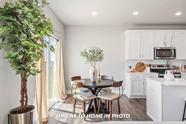 kitchen featuring tasteful backsplash, appliances with stainless steel finishes, dark wood-type flooring, and white cabinets