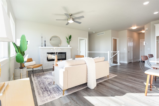 living room with ceiling fan, a high end fireplace, and hardwood / wood-style flooring