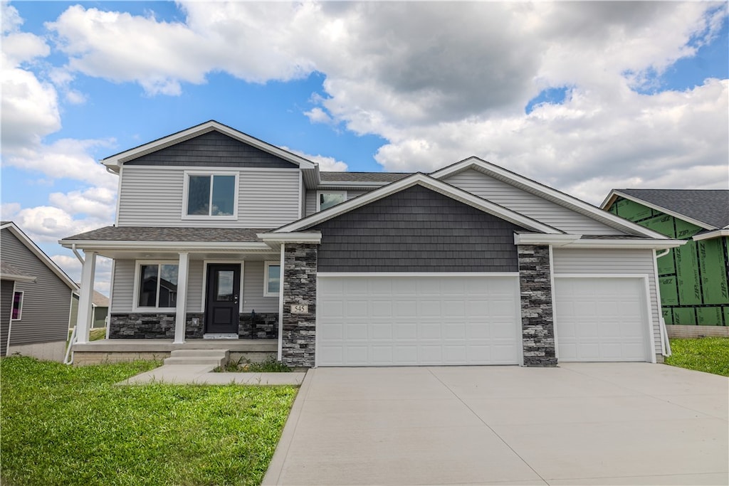 craftsman-style home with a garage, a front lawn, and a porch