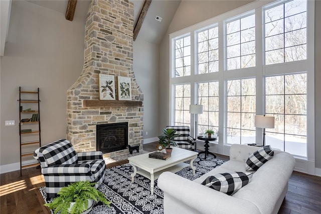 living room with a healthy amount of sunlight, dark hardwood / wood-style flooring, and beam ceiling