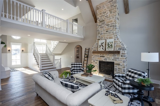 living room with high vaulted ceiling, a fireplace, brick wall, beamed ceiling, and wood-type flooring