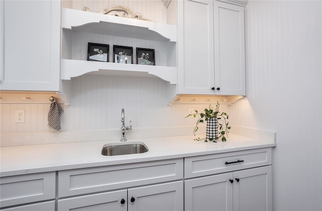 kitchen featuring backsplash, white cabinetry, and sink