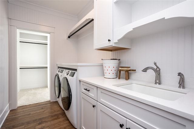 laundry area with dark hardwood / wood-style floors, sink, crown molding, washer and clothes dryer, and cabinets