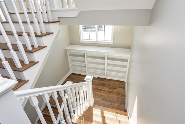 staircase featuring a notable chandelier and wood-type flooring