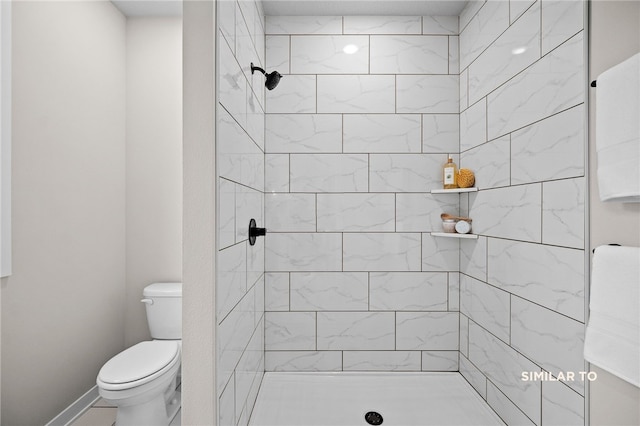 bathroom with toilet and a tile shower