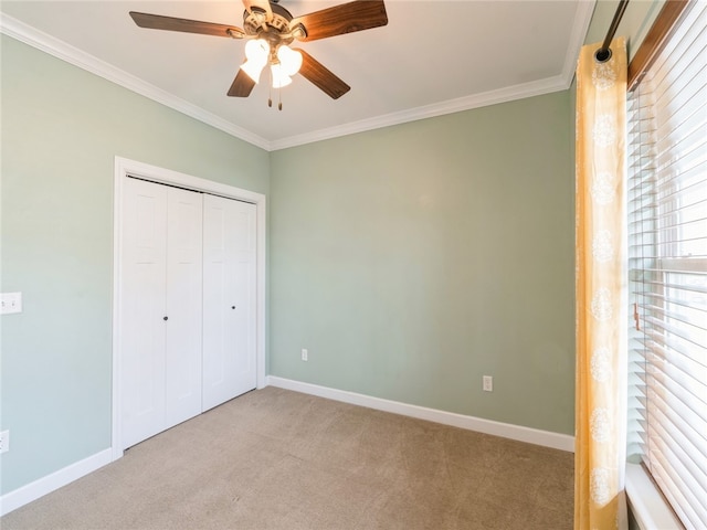 unfurnished bedroom featuring carpet, ceiling fan, and crown molding