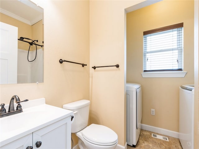 bathroom featuring tile floors, washer / dryer, vanity, and toilet