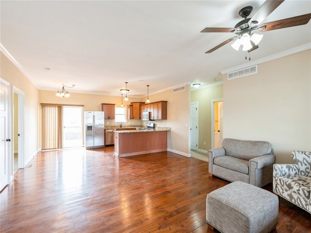 living room featuring ceiling fan with notable chandelier, hardwood / wood-style floors, and ornamental molding