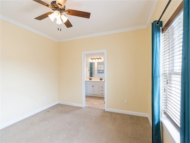 empty room featuring ceiling fan, crown molding, and light carpet