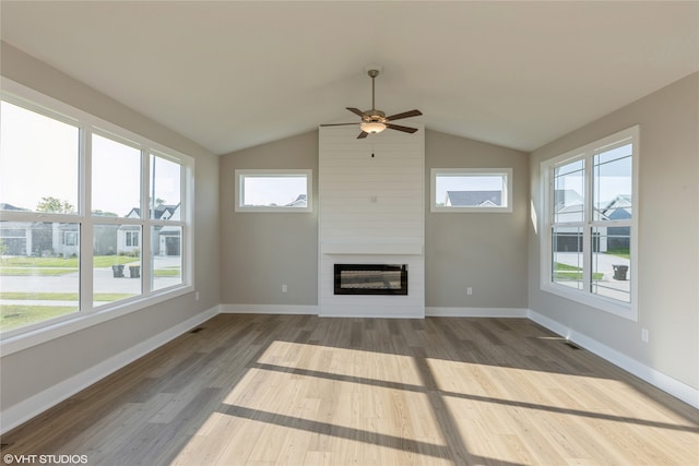 unfurnished living room featuring lofted ceiling, ceiling fan, hardwood / wood-style flooring, and a fireplace