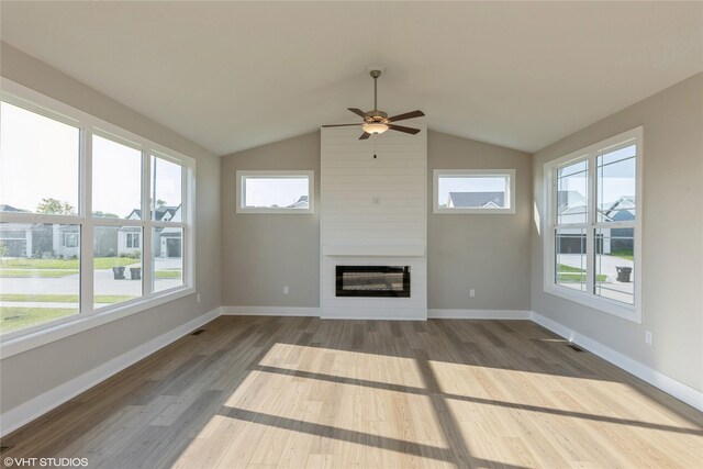 unfurnished living room with hardwood / wood-style floors, a fireplace, and vaulted ceiling