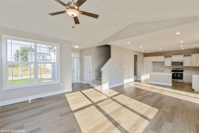 unfurnished living room with lofted ceiling, ceiling fan, and light hardwood / wood-style floors