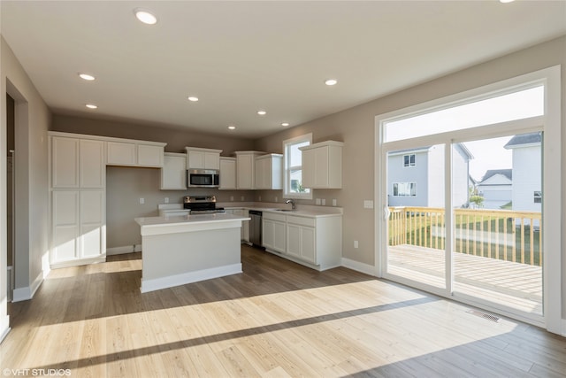 kitchen featuring a center island, sink, appliances with stainless steel finishes, and white cabinets