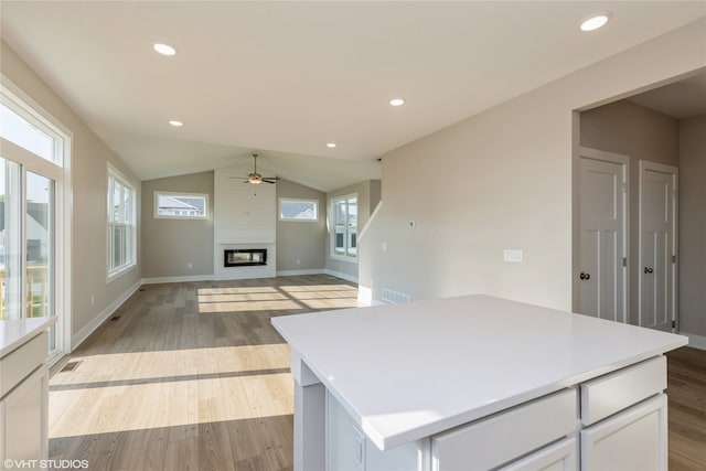 kitchen with a center island, plenty of natural light, a fireplace, and ceiling fan