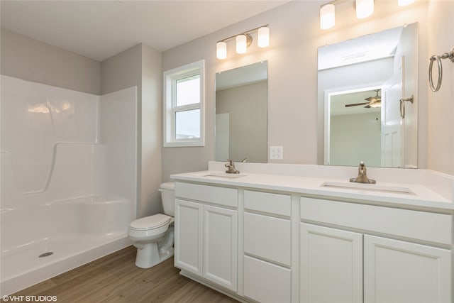 bathroom with vanity, hardwood / wood-style floors, walk in shower, toilet, and ceiling fan