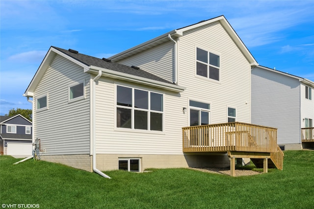 back of property with a yard, a wooden deck, and a garage