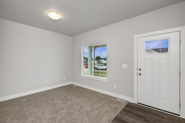 foyer with dark hardwood / wood-style floors and a textured ceiling