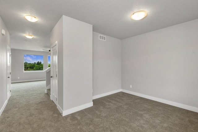 carpeted spare room with a textured ceiling