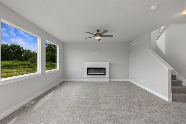 unfurnished living room with carpet flooring and ceiling fan